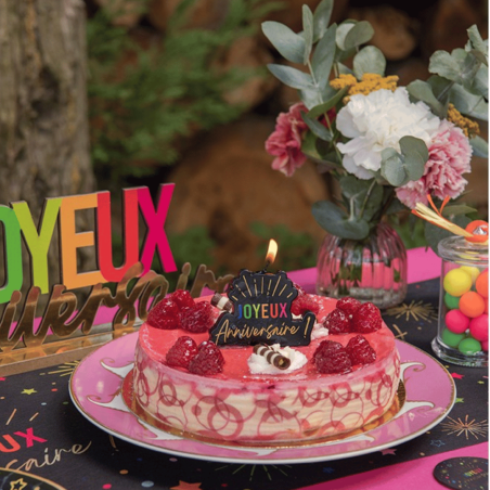 Multi-colored happy birthday candle on a cake